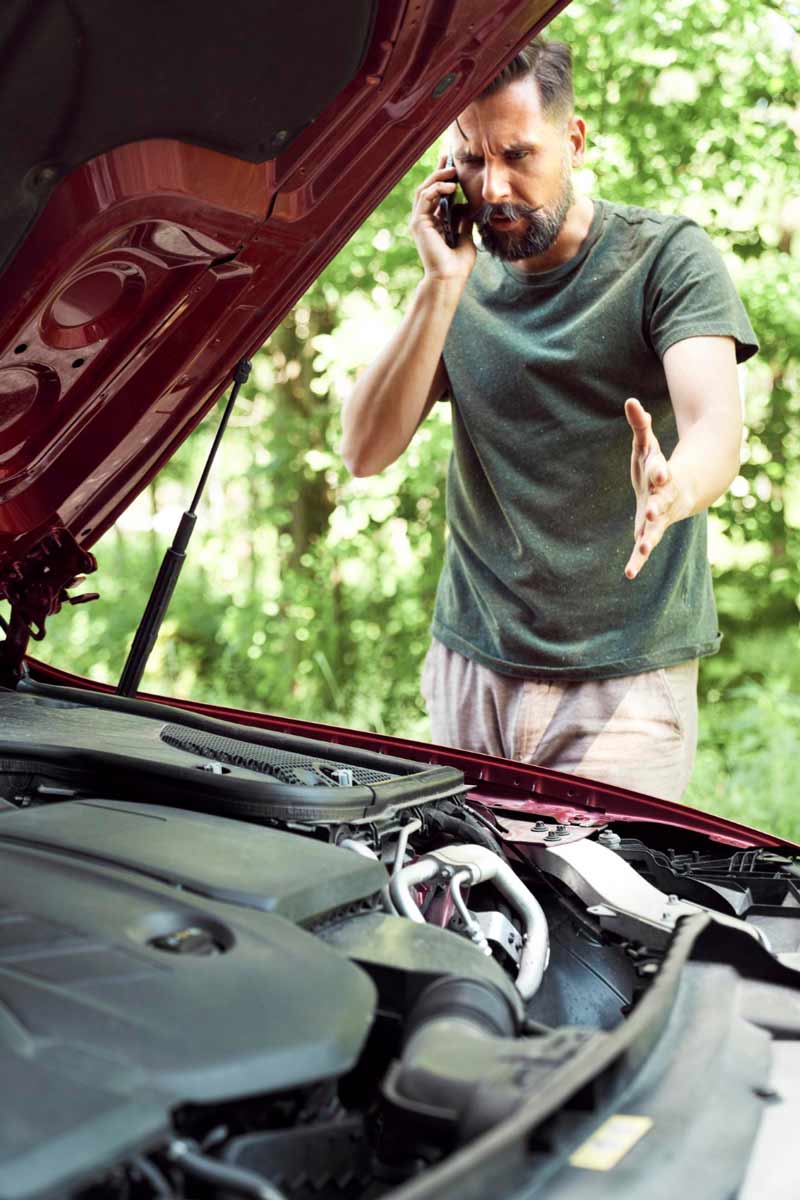 Junger Mann prüft Getriebeschaden bei Schrottauto Ankauf Goch
